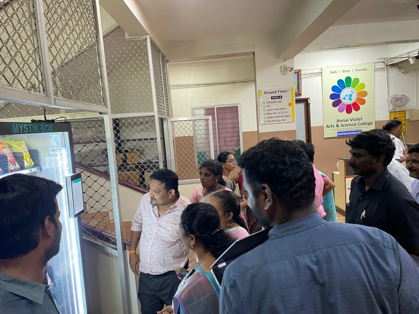 Staff and students gathered around a newly installed Mystik Box machine