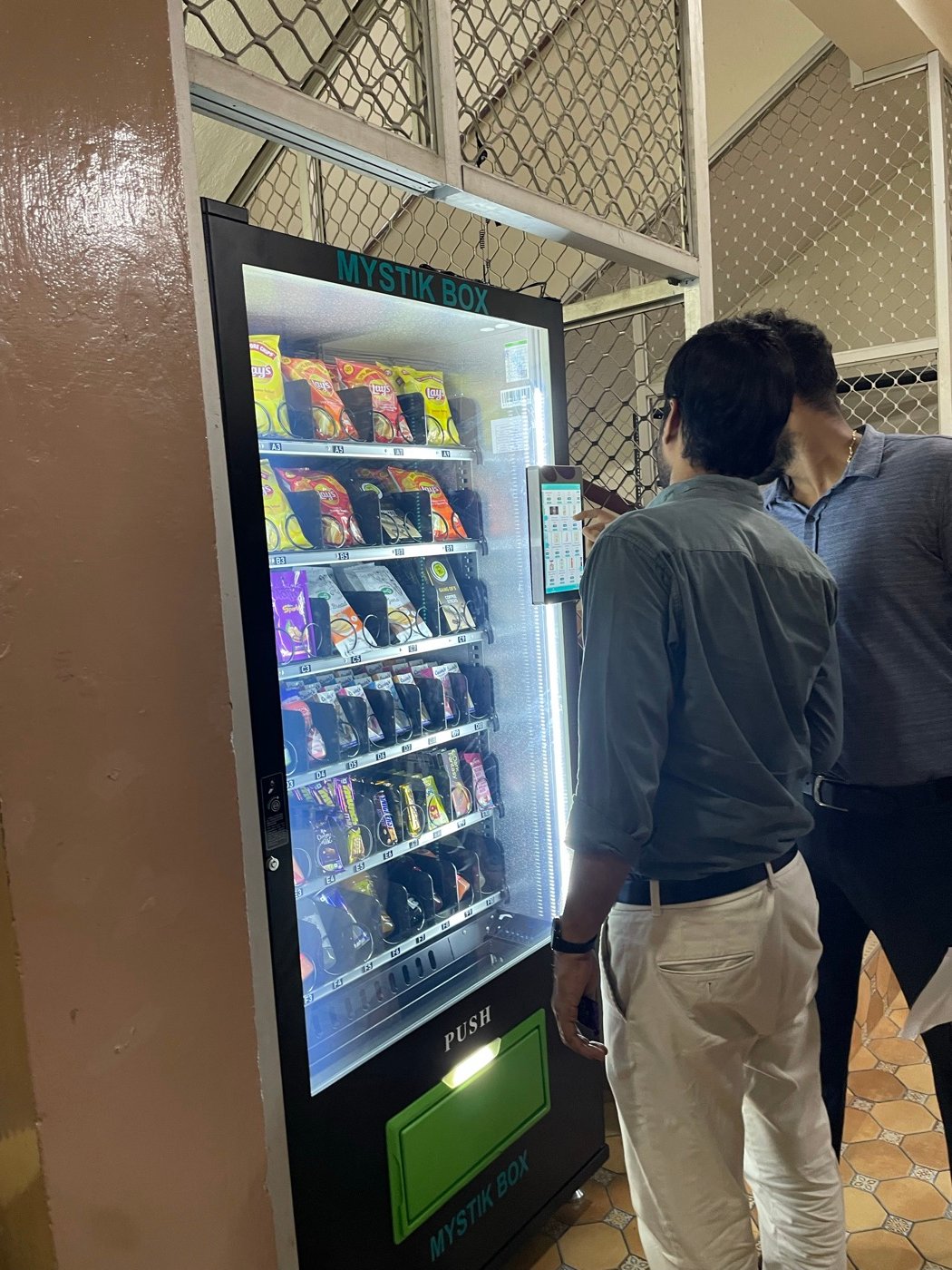 Close-up of a person selecting an item on the Mystik Box touchscreen