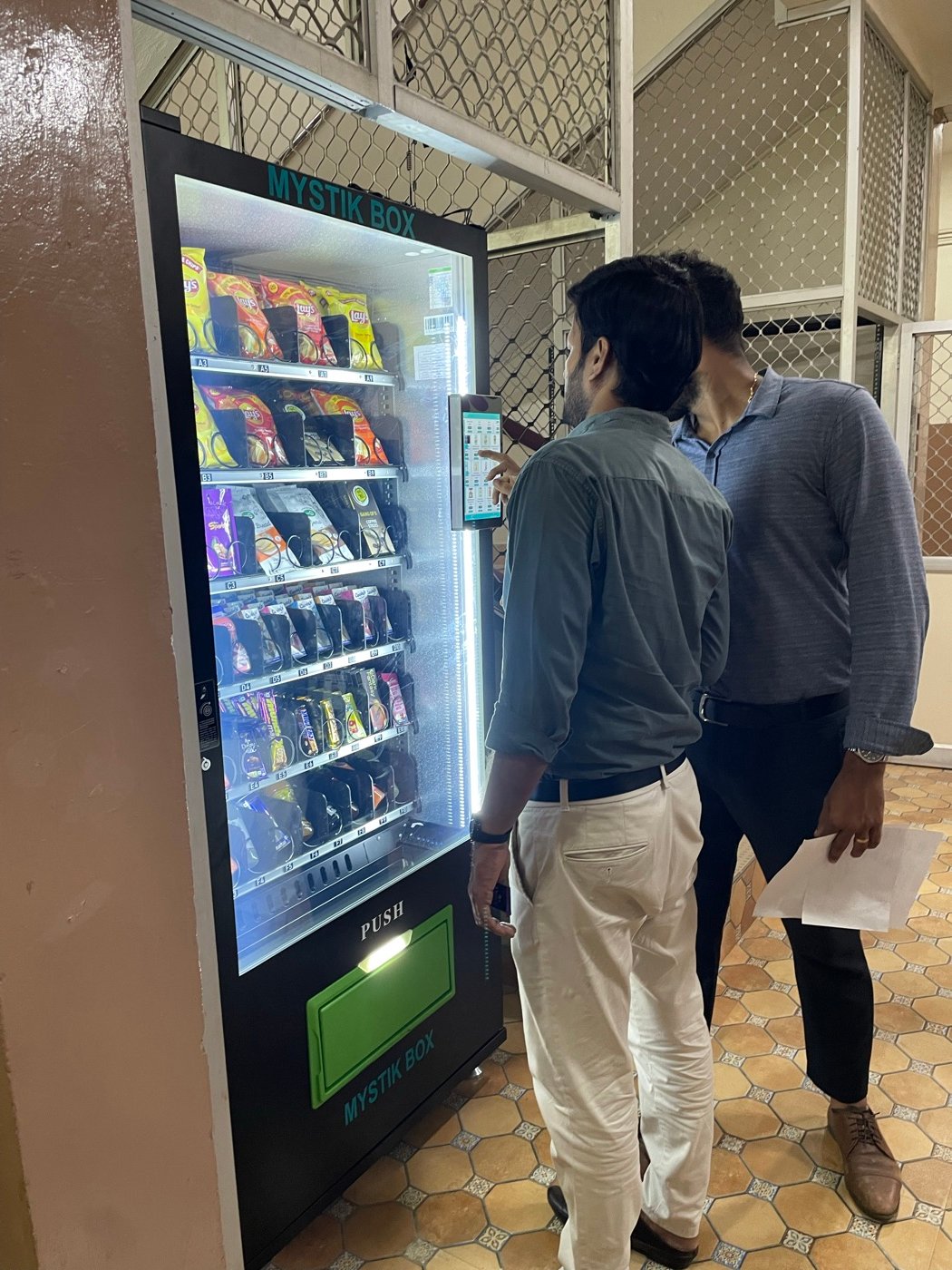 Students using the touchscreen on a Mystik Box machine