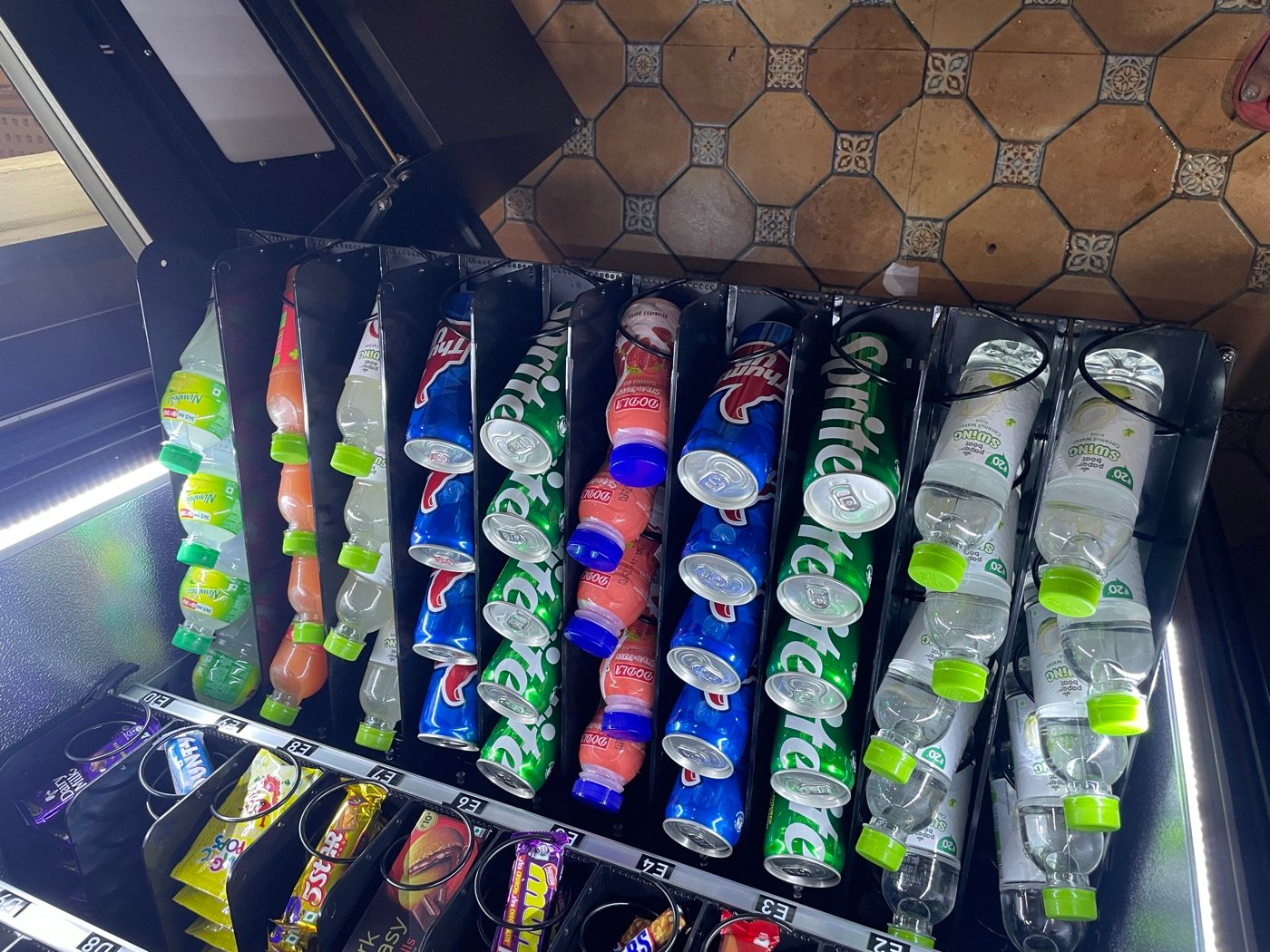 Chilled beverage section of a Mystik Box vending machine with soft drinks and water